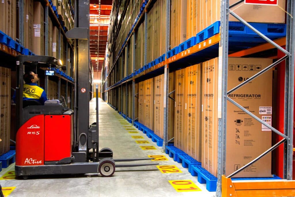 the forklift wants to transport a LG refrigerator in a warehouse