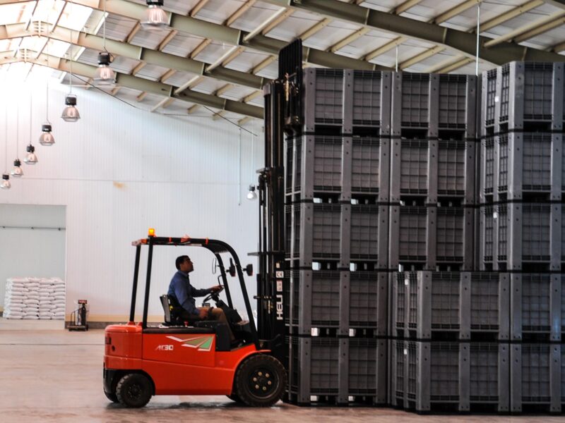 A forklift is transporting the stack of box pallets