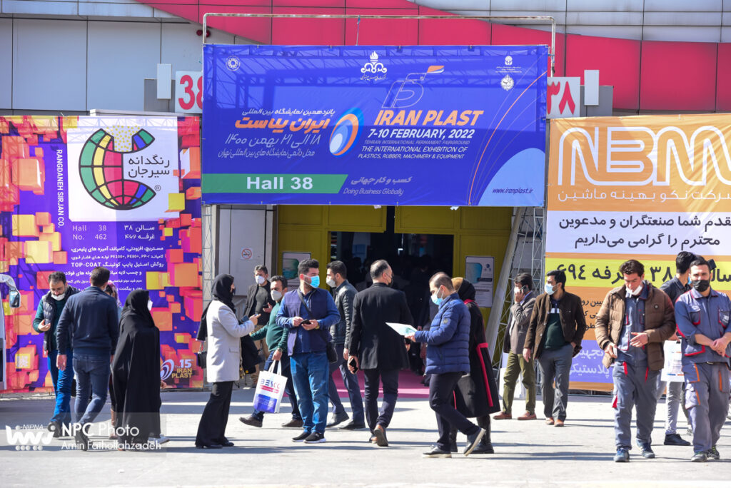 the photo is the entrance of Hall 38 at Iran Plast Exhibition with attendees and visitors. 