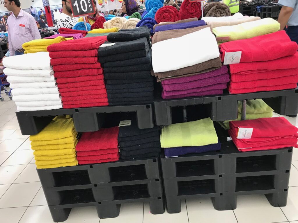 The light-duty plastic pallet holding clothes in a shop as a display plastic pallet 
