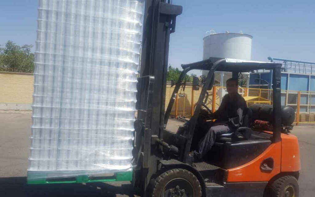 The left photo show a fork-lift transporting a pile of cans loaded on a plastic pallet 