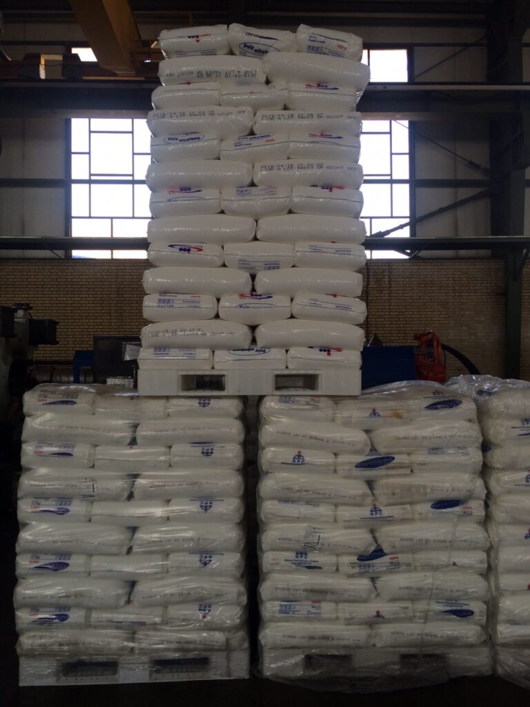 the right photo describes a white plastic pallets in medium-duty loading capacity with 3 skid runners holding many bags of plastic raw material 