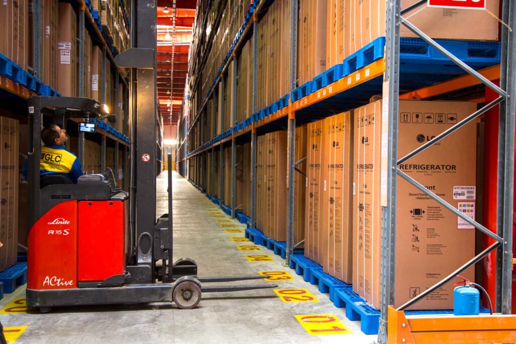 The picture show a forklift and operator in LG warehouse full of LG products in the racking systems such as refrigerator